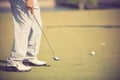 Golf player at the putting green hitting ball into a hole. Royalty Free Stock Photo