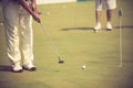 Golf player at the putting green hitting ball into a hole. Royalty Free Stock Photo