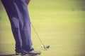 Golf player at the putting green hitting ball into a hole. Royalty Free Stock Photo