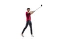 Golf player in a red shirt taking a swing isolated on white studio background Royalty Free Stock Photo