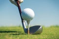 Golf player sets the ball on tee, preparing for play