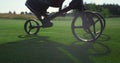 Golf player using clubs trolley on course. Golfer legs walk take sport equipment Royalty Free Stock Photo