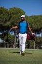 Golf player walking and carrying bag Royalty Free Stock Photo