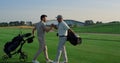 Golf players shaking hands on grass field. Two friends meeting play on weekend. Royalty Free Stock Photo
