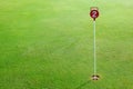 Golf practice putting green hole and marked with a red sign Royalty Free Stock Photo