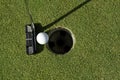 Golf putter and ball next to the cup Royalty Free Stock Photo