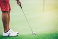 Golf putter putting athletes to hit a golf ball into the hole to Royalty Free Stock Photo