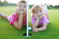 Golf sister girls relaxed laying green hole ball Royalty Free Stock Photo