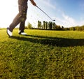 Golf swing on the course. Golfer performs a golf shot from the f Royalty Free Stock Photo