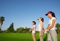 Golf three woman in a row green grass course Royalty Free Stock Photo