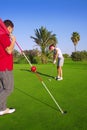 Golf woman putting gol ball and man holds flag Royalty Free Stock Photo