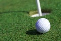 Golfball in front of the hole Royalty Free Stock Photo