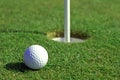 Golfball in front of the hole Royalty Free Stock Photo