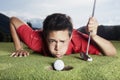 Golfer blowing ball into cup. Royalty Free Stock Photo