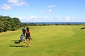 Golfer and caddy girl walking