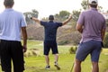 Golfer celebrates drive with friends looking on