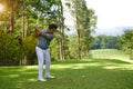 Golfer driving golf ball on beautiful golf course with clear blue sky in the mountains Royalty Free Stock Photo