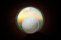 Golfer at golf ball view from inside the hole of cup in the green golf club play and lens flare on sun set evening time gold sky