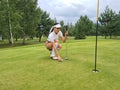 Golfer on golf course putts up on green course Royalty Free Stock Photo