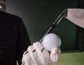 Golfer in golf gloves with iron club and equipment golf ball Royalty Free Stock Photo