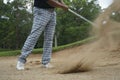 Golfer hitting golf ball on bunker of sand in course Royalty Free Stock Photo