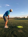 Golfer hitting a golf balls for practice from a back view.