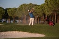 Golfer hitting a sand bunker shot on sunset Royalty Free Stock Photo