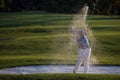 Golfer hitting a sand bunker shot on sunset Royalty Free Stock Photo