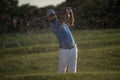 Golfer hitting a sand bunker shot on sunset Royalty Free Stock Photo