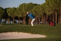 Golfer hitting a sand bunker shot on sunset Royalty Free Stock Photo