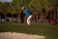 Golfer hitting a sand bunker shot on sunset Royalty Free Stock Photo