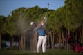 Golfer hitting a sand bunker shot on sunset Royalty Free Stock Photo