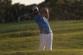 Golfer hitting a sand bunker shot on sunset Royalty Free Stock Photo