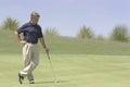 Golfer leaning against putter