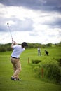 Golfer pitching over obstacle