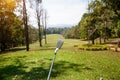 The golfer is pointing with a golf club. Showing a direction and measuring the trajectory. Green grass golf course Royalty Free Stock Photo