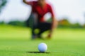 Golfer putt golf ball into hole on the green at golf course