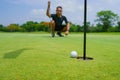 Golfer putt golf ball into hole on the green at golf course Royalty Free Stock Photo