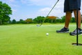 Golfer putt golf ball into hole on the green at golf course