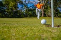 Golfer putting ball on the green golf, lens flare on sun set evening time. Golfer action to win after long putting golf ball in to