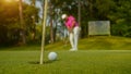 Golfer putting ball on the green golf, lens flare on sun set evening time Royalty Free Stock Photo