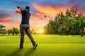 Golfer putting golf ball on the green golf, lens flare on sun set evening time, Golfer hitting golf shot with club on course Royalty Free Stock Photo