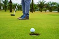 Golfer putting golf ball on the green golf, lens flare on sun set evening time, Pro Golf long putting golf ball in to the hole, su Royalty Free Stock Photo