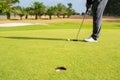 Golfer putting golf ball on the green golf, lens flare on sun set evening time. Royalty Free Stock Photo