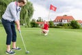 Golfer on putting green about to take the shot Royalty Free Stock Photo