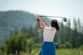 Golfer sport course golf ball fairway. People lifestyle woman playing game golf and hitting go on green grass Royalty Free Stock Photo