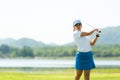 Golfer sport course golf ball fairway. People lifestyle woman playing game golf tee off on the green grass Royalty Free Stock Photo