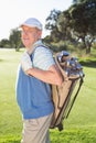 Golfer standing holding his golf bag smiling at camera Royalty Free Stock Photo