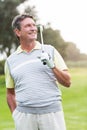 Golfer standing and swinging his club smiling at camera Royalty Free Stock Photo