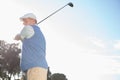 Golfer standing and swinging his club Royalty Free Stock Photo